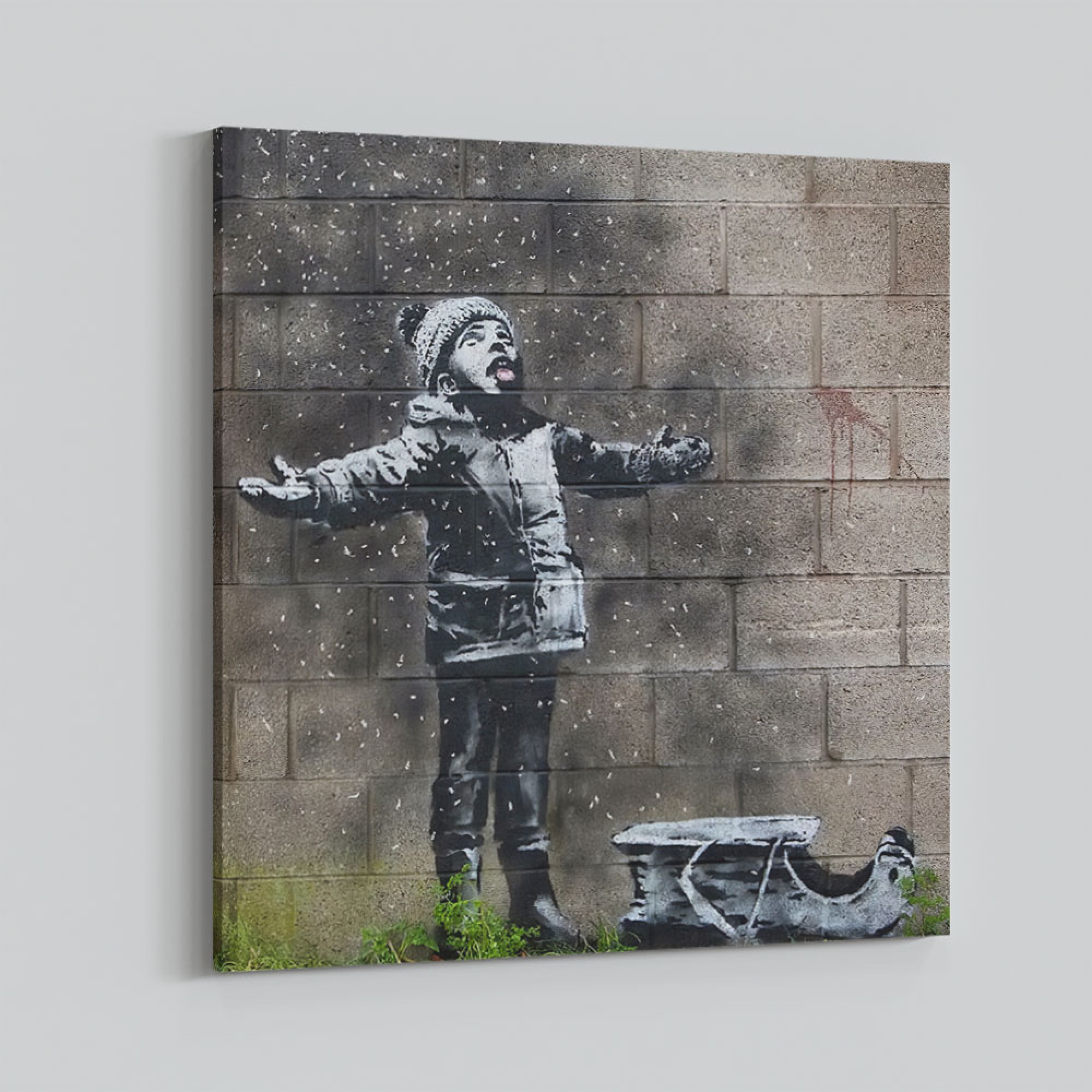 A child in winter clothing throwing snowballs against a brick wall